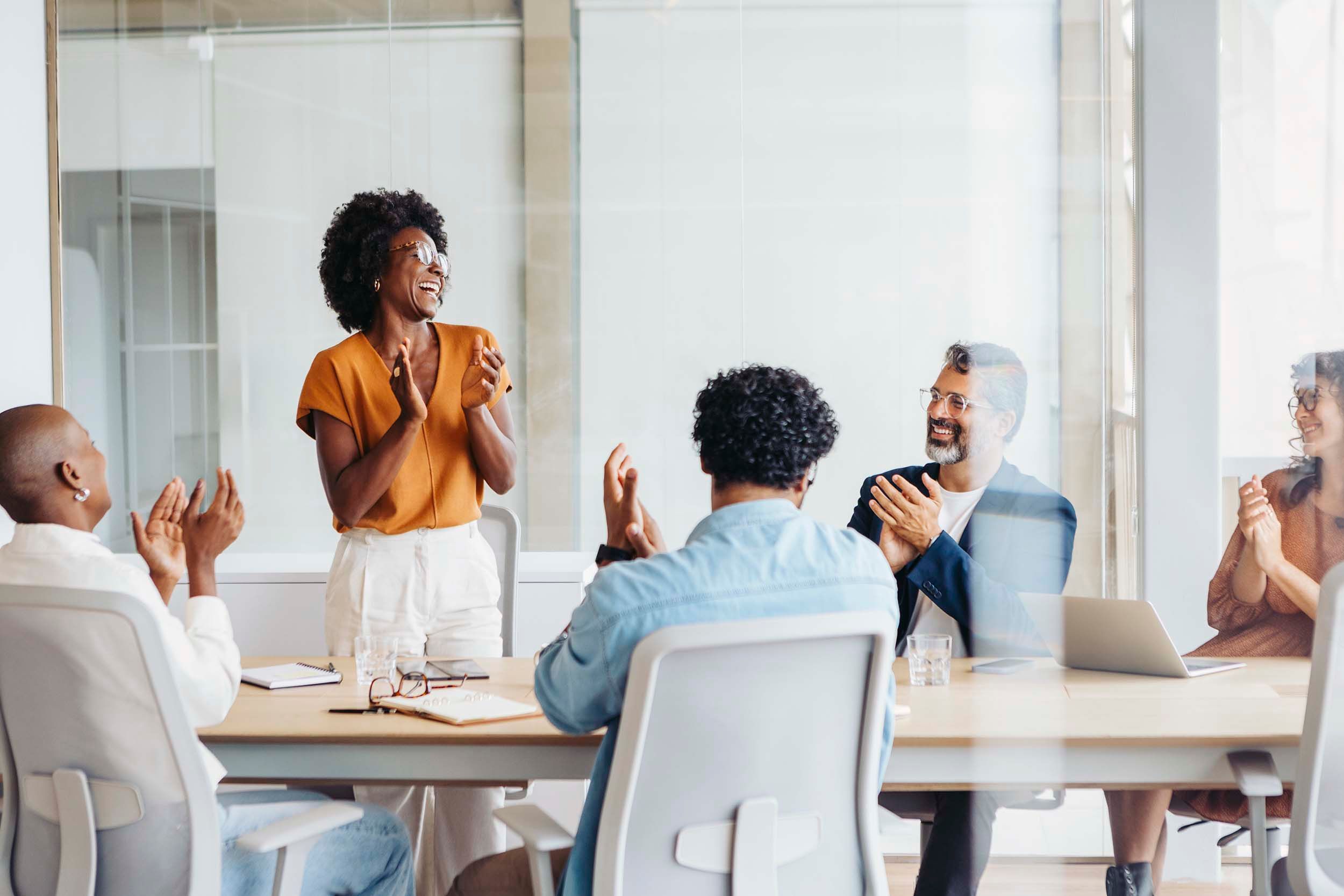 colleagues clapping hands in meeting