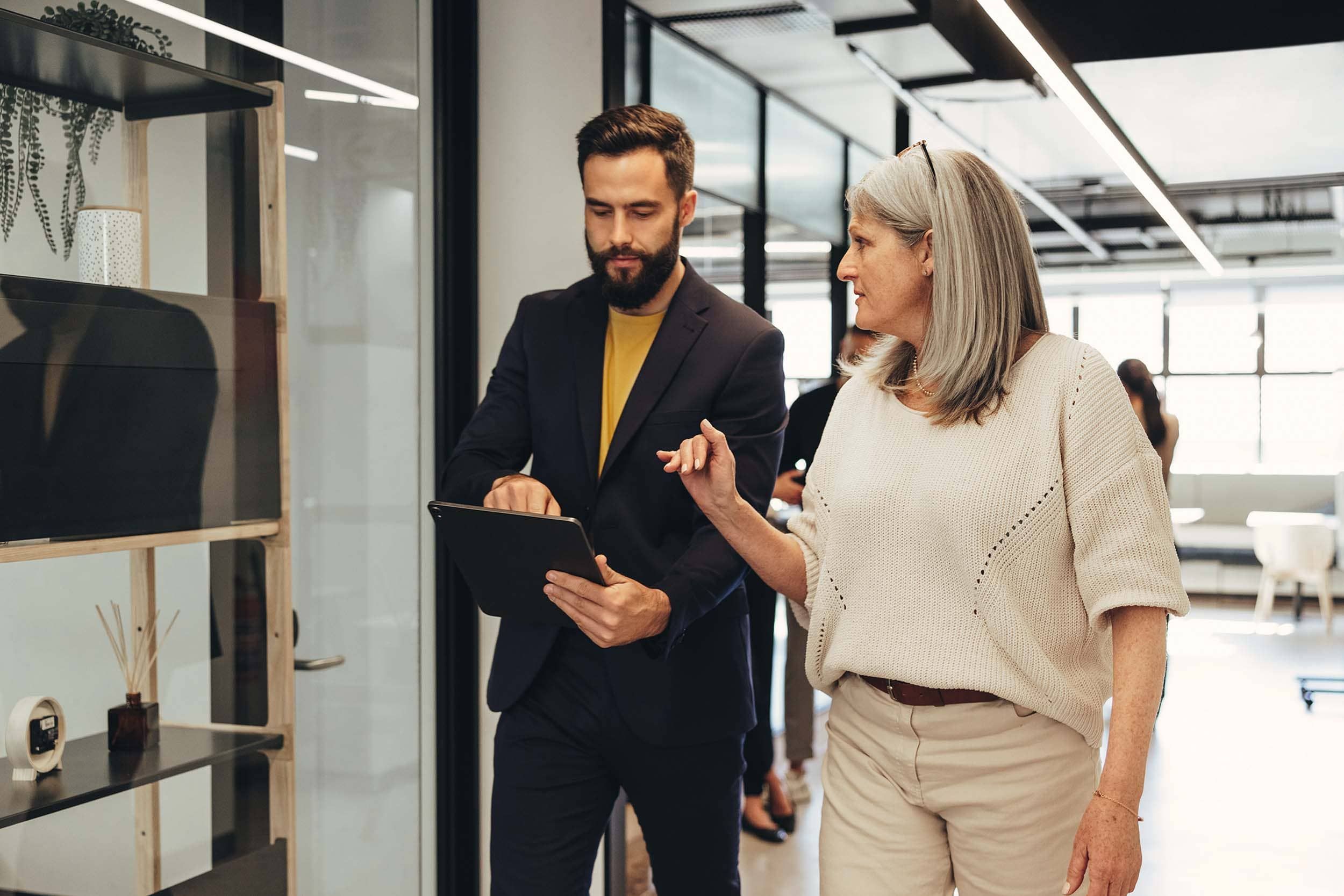 colleagues walking and looking at ipad