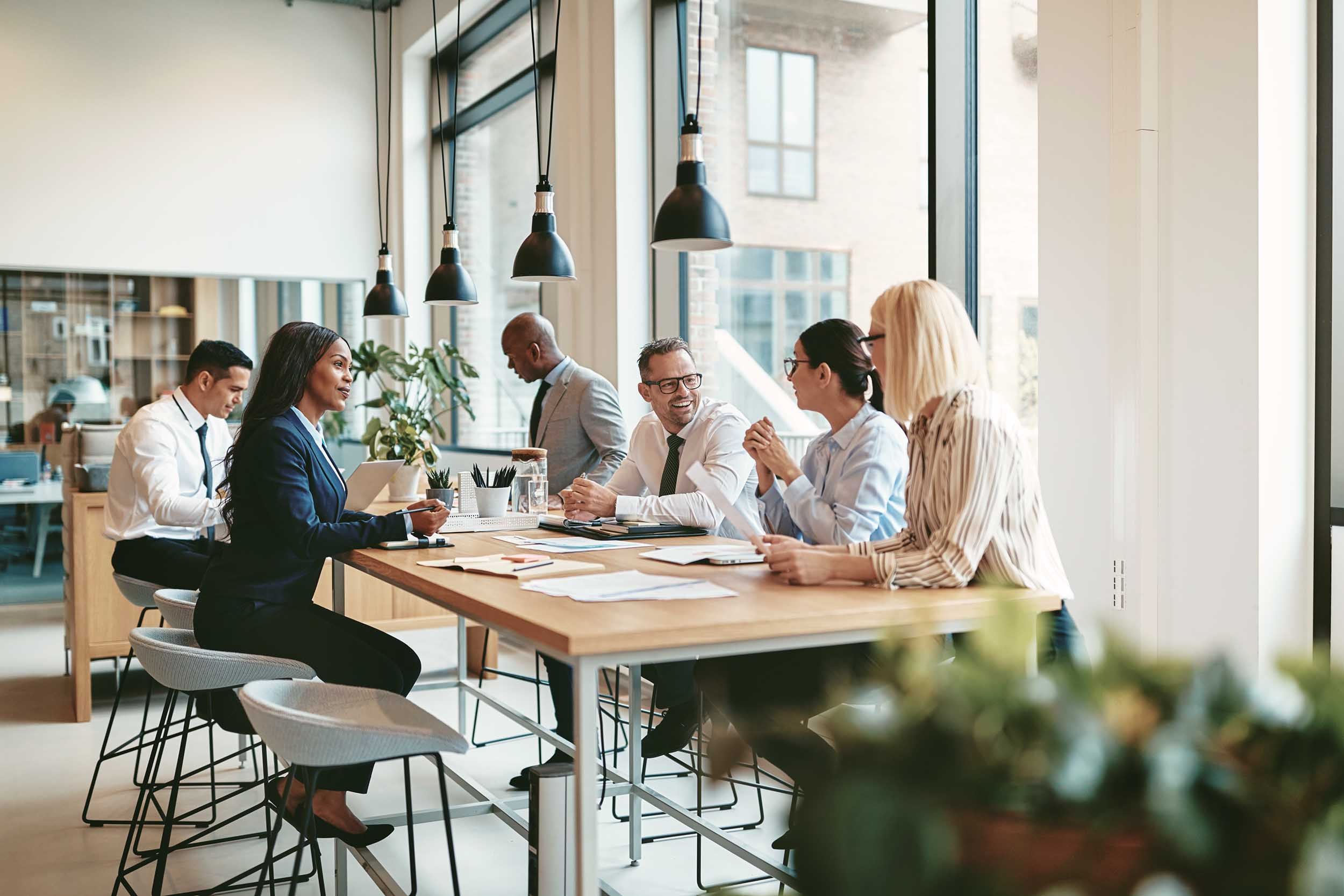 colleagues working on tall tables in a hybrid office