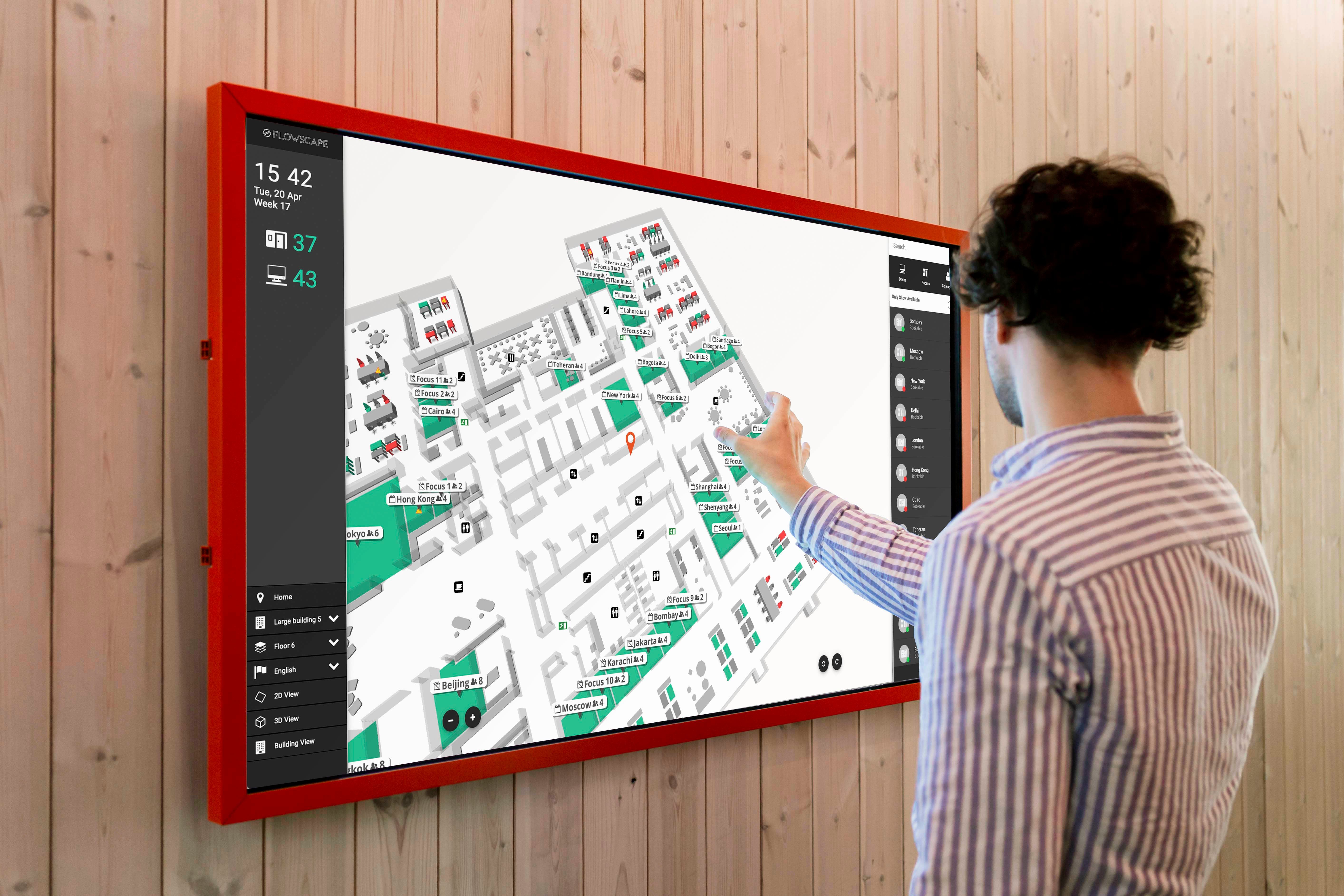 man checking meeting room capacity and other room reservations on a kiosk screen